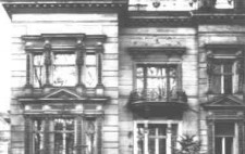 An archive photograph showing the outside of an elegant villa, large windows, a balcony and a sweeping staircase to the raised front door.