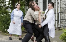 Inmate Otto, is wrestled to the ground outside the institution by two orderlies. Otto cries out as the nurse looks on in distress.