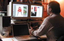 Bryan Panks sits at a desk in front of two computer monitors which display a greenscreen shot of Nell (Maia Tamraker) and her mother (Kiren Jogi). This image has been dissected to show Nell's skirt and legs, against backdrops of white and black.