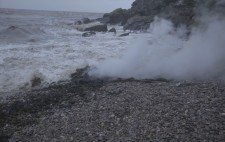 Out of shingle, seaweed and seawater billows steam.