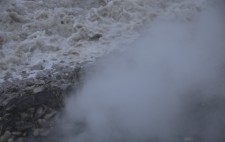 Out of shingle, seaweed and seawater billows steam.