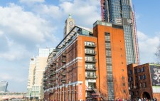 Daytime on the foreshore, the Oxo tower in the background. The river is full, the water partway up the stairs and covers the foreshore.