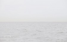 A band of sea and a band of sky, in greys, separated by a sharp line of horizon.