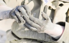 Liz’s hands are coated in thick, wet mud, camouflaged against her coat.