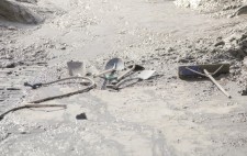 Scattered across the slipway is a head of spades, a hosepipe and a scraper. Pooled around is mud and water, left by the tide.