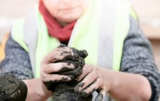 Liz shapes the extruded mud into spheres, ready for sculpting.