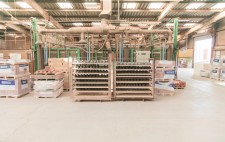 In the centre of a large manufacturing warehouse, metal shelf unit hold rows of clumped mud.