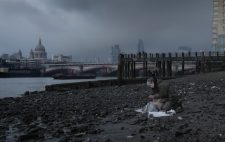 Against a backdrop of St Paul's Cathedral and Blackfriars Bridge, dark clouds rolling in, Liz sculpts the figures, almost merging into the dank shingle foreshore.