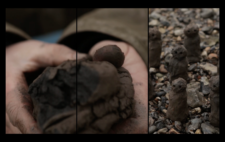 Screen is split vertically into three. Left and centre, hands mould a lump of dark brown mud, deep black at its centre. Right, five completed scupltred human figures stand, half-camouflaged, on riverbank stones.